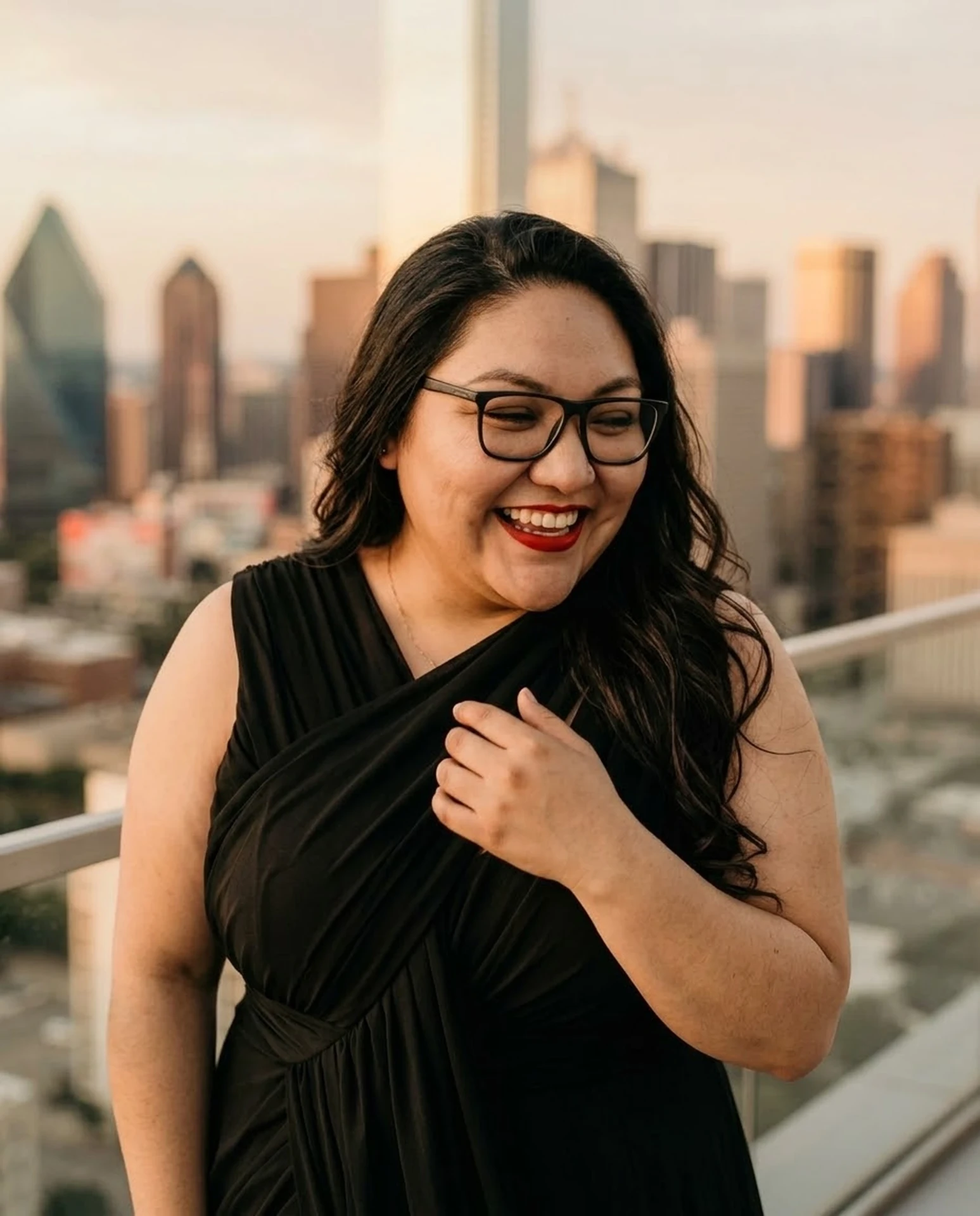 Liz laughing on a rooftop at sunset